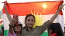 Gadis Kurdi Iran berpose mengibarkan bendera Kurdi saat mengampanyekan referendum untuk kemerdekaan di kota Bahirka, Irak Utara (21/9). (AFP Photo/Safin Hamed)