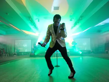 Peniru gaya Elvis Presley, Ricky Aron dari Liverpool tampil dalam Festival Elvis Skotlandia yang digelar pertama kali di Grangemouth, 8 April 2016. Acara ini memikat penonton yang ingin menyaksikan aksi kontestan mirip Elvis Presley. (Andy Buchanan/AFP)