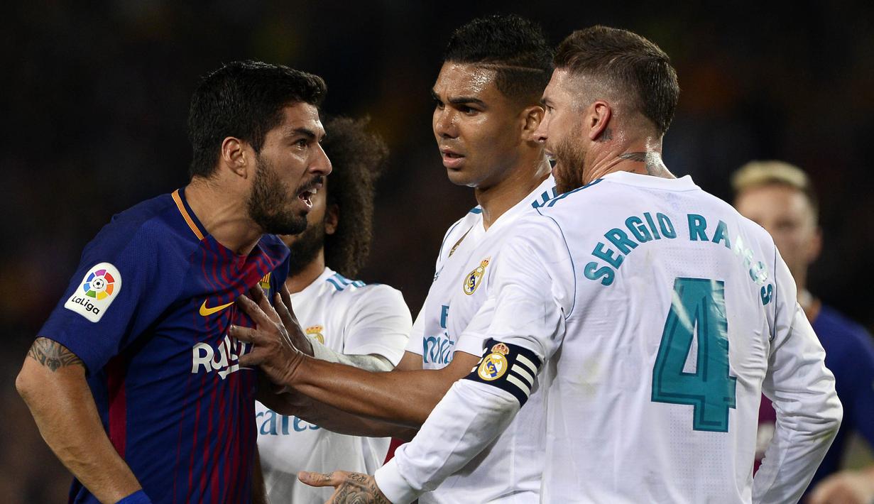 Striker Barcelona, Luis Suarez, bersitegang dengan bek Real Madrid, Sergio Ramos, pada laga La Liga Spanyol di Stadion Camp Nou, Barcelona, Minggu (6/5/2018). Kedua klub bermain imbang 2-2. (AFP/Josep Lago)