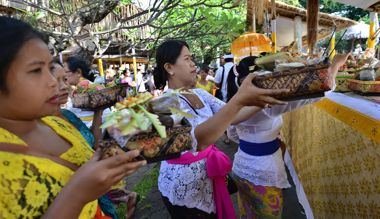 Sejumlah umat Hindu Bali membawakan sesajen untuk sembahyang Hari Raya Galungan di Pura Jagat Natha di Denpasar, Bali (1/11). Galungan dimaknai sebagai hari kemenangan Dharma (Kebaikan) melawan Adharma (Keburukan). (AFP Photo/Sonny Tumbelaka)