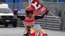 Marc Marquez nenbawa bendera usai tampil sebagai juara pada balapan MotoGP San Mariono di Sikuit Marco Simoncelli, Misano Adriatico, Italia (10/9/2017). (AP/Antonio Calanni)