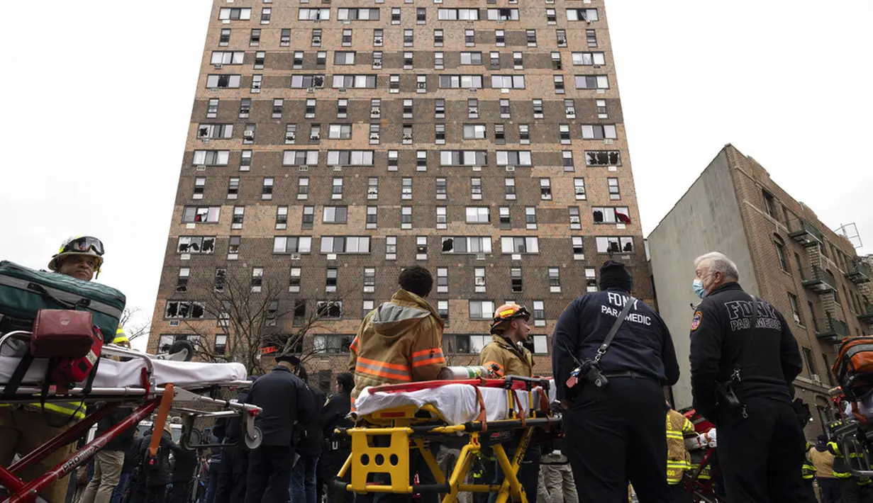 Petugas darurat bekerja di lokasi kebakaran gedung apartemen di Bronx, New York, Amerika Serikat, 9 Januari 2022. Sebanyak 19 orang tewas dalam kebakaran maut tersebut. (AP Photo/Yuki Iwamura)