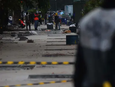 Pekerja menyelesaikan penataan jalur pedestrian di sepanjang Jalan Jenderal Sudirman - Jalan MH Thamrin, Jakarta, Selasa (10/7). Pelebaran trotoar untuk mendukung perhelatan Asian Games itu  hingga kini belum rampung. (Merdeka.com/Imam Buhori)