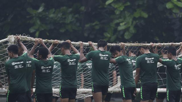 Para pemain Timnas Indonesia U-22 gotong royong mengangkat gawang. (Bola.com/Vitalis Yogi Trisna)