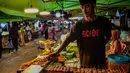 <p>Penjual makanan jalanan mendirikan kios mereka untuk menjual makanan kepada umat Muslim untuk berbuka puasa selama bulan suci Ramadhan di pasar malam di provinsi Narathiwat, Thailand selatan (21/4/2022). (AFP/Madaree Tohlala)</p>