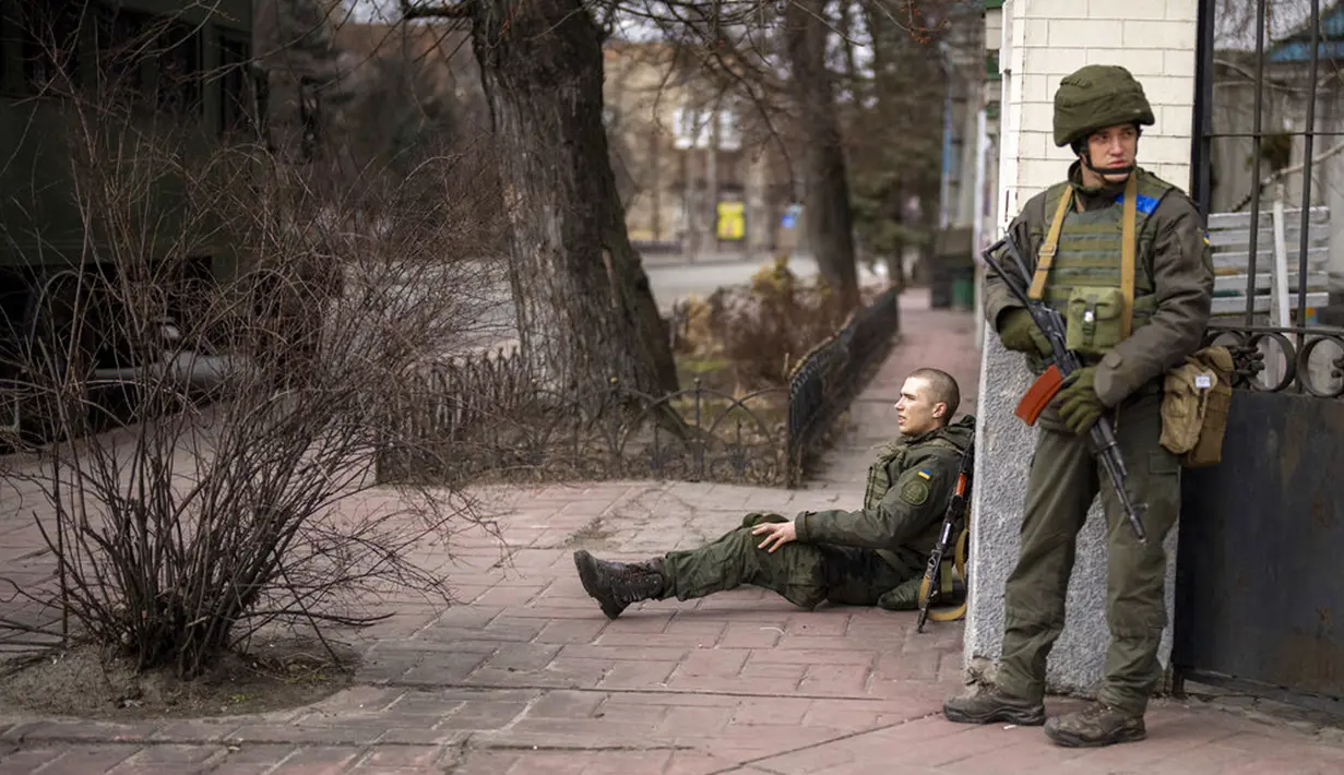 Seorang tentara Ukraina duduk terluka dalam baku tembak di dalam Kota Kiev, Ukraina, Jumat (25/2/2022). Rusia menekan invasinya sampai ke pinggiran Kiev setelah melepaskan serangan udara di kota-kota dan pangkalan militer serta mengirimkan pasukan dan tank dari tiga sisi. (AP Photo/Emilio Morenatti)