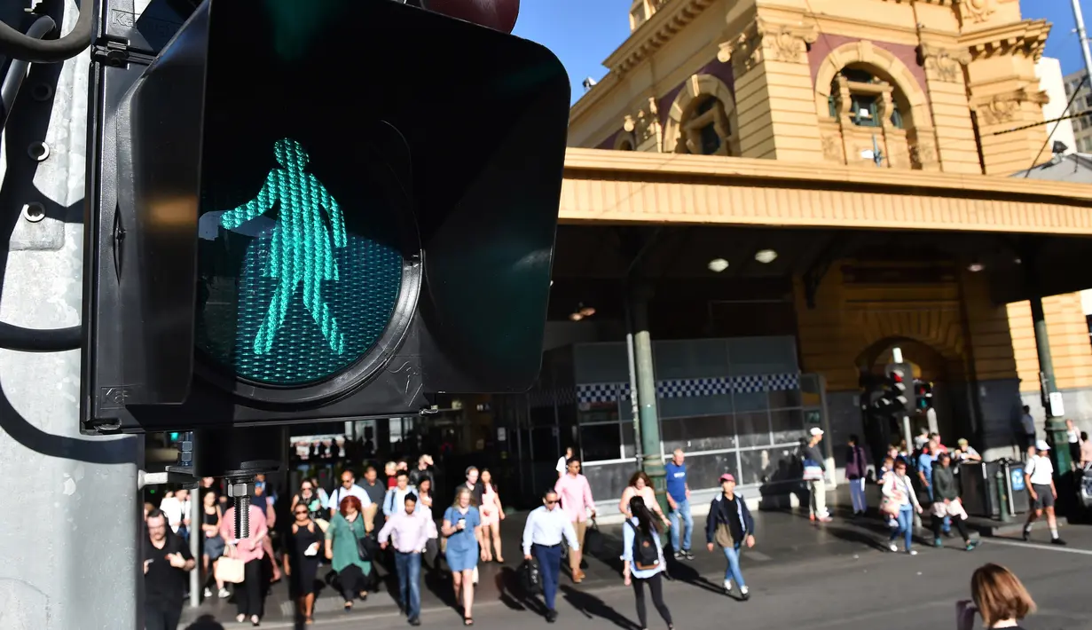 Lampu lalulintas bertanda perempuan menyala saat peringatan hari perempuan Internasional di Swanston Street dekat Stasiun Flinders Street, Melbourne, Australia, Rabu (8/3). Hal ini terkait peringatan Hari Perempuan Internasional. (AFP Photo / Paul Crock)
