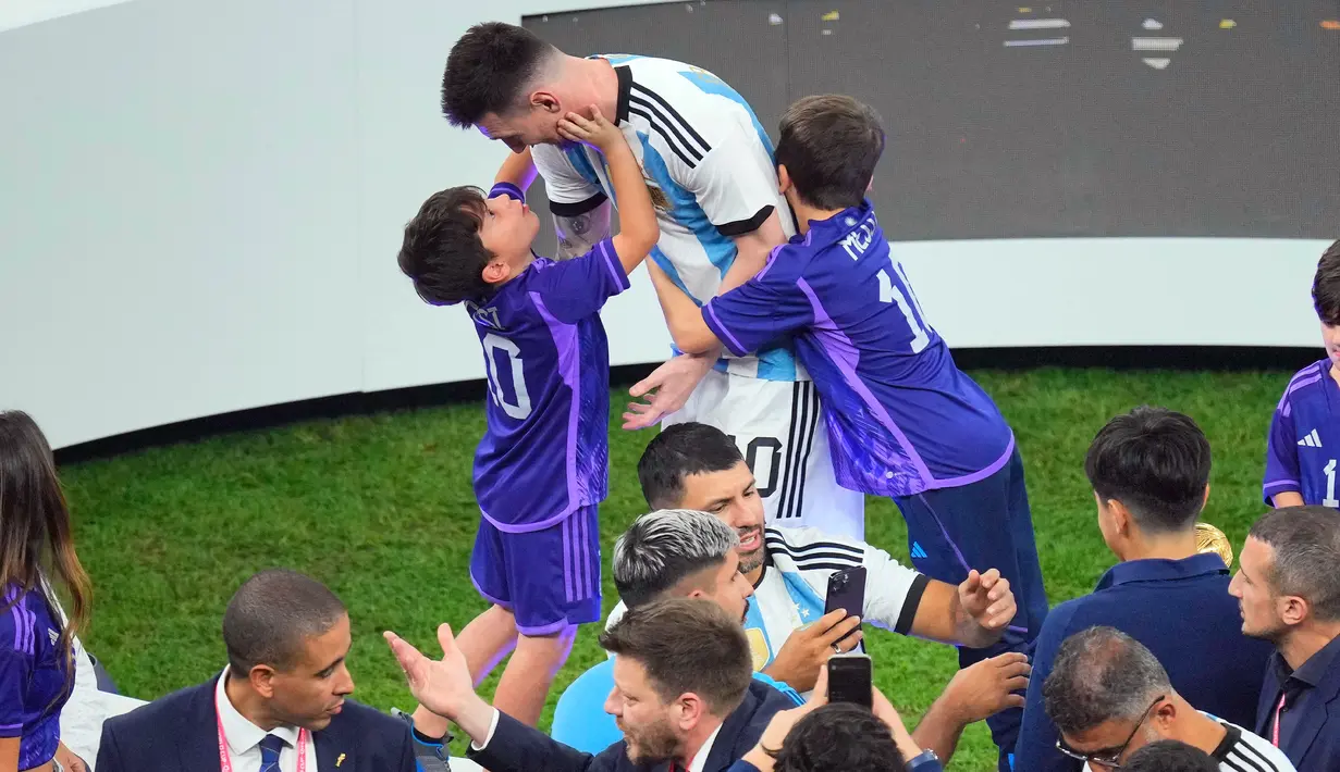 Pemain Argentina Lionel Messi menghampiri anak-anaknya setelah mengalahkan Prancis pada pertandingan sepak bola final Piala Dunia 2022 di Stadion Lusail, Lusail, Qatar, 18 Desember 2022. Argentina menang 4-2 atas Prancis melalui drama adu penalti setelah pertandingan berakhir imbang 3-3. (AP Photo/Hassan Ammar)