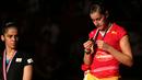 Carolina Marin memperhatikan medali emas yang diraihnya, sementara Saina Nehwal meliriknya. Minggu (16/8/2015). (Bola.com/Arief Bagus)