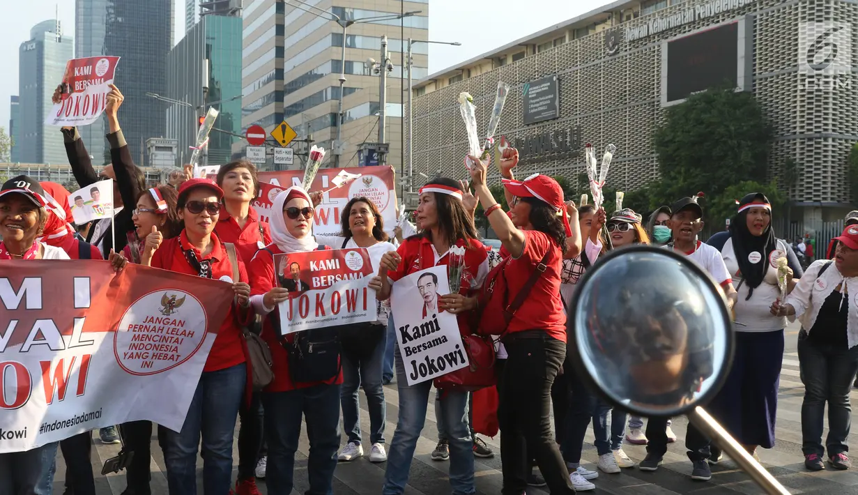 Relawan Jokowi saat membagikan bunga mawar di Kawasan Sarinah, Jakarta, Minggu (29/9/2019). Aksi bagi bunga tersebut merupakan aksi damai kami bersama Jokowi. (Liputan6.com/Angga Yuniar)