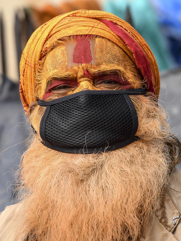 Seorang sadhu (lelaki suci Hindu) mengenakan masker berpose untuk foto-foto menjelang festival Hindu 'Maha Shivaratri' di Kathmandu (20/2/2020). Festival ini  didedikasikan untuk 'Malam Besar Siwa', dewa Hindu yang berdoa dan berpuasa bagi orang percaya. (AFP/Prakash Mathema)