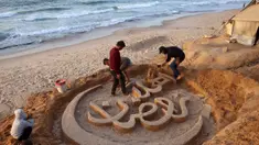 Warga membantu seniman Palestina, Yazeed Abu Jarad, saat ia membuat patung pasir dengan pesan ucapan "Selamat Datang, Ramadan" di sepanjang pantai di Khan Younis, selatan Gaza pada 17 Februari 2026. (Bashar Taleb/AFP)