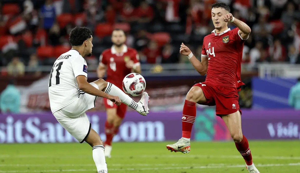 Gelandang Timnas Irak, Zidane Iqbal (kiri) mengontrol bola untuk melewati gelandang Timnas Indonesia, Ivar Jenner pada laga pertama Grup D Piala Asia 2023 Qatar di Ahmad bin Ali Stadium, Al-Rayyan, Doha, Senin (15/1/2024). (AFP/Karim Jaafar)