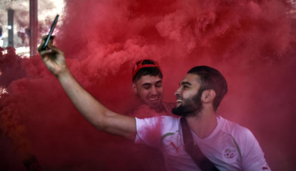 Seorang fans dari Polandia melakukan selfie ditengah kepulan flare sebelum laga grup C Euro Cup 2016 antara Ukraina melawan Polandia di Marseille (21/6/2016). (AFP/Bulent Kilic)