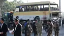 Petugas keamanan berjaga didekat minibus yang terkena serangan bunuh diri di Kabul, Afghanistan, Senin (20/6). Sebanyak 14 orang tewas akibat serangan ini. (REUTERS / Omar Sobhani)