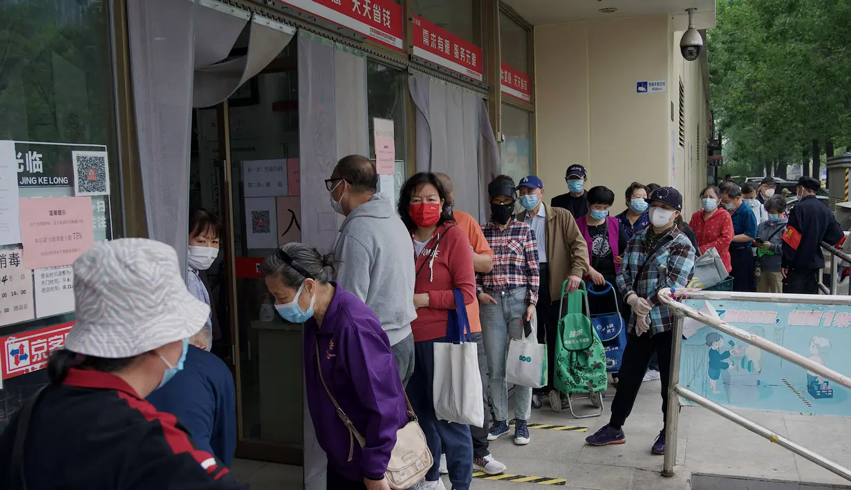 <p>Orang-orang membeli makanan dan kebutuhan rumah tangga di sebuah supermarket di Beijing pada 25 April 2022. Kekhawatiran penguncian Covid memicu pembelian panik dan antrean panjang untuk pengujian massal di Beijing pada 25 April ketika otoritas China bergegas untuk membasmi wabah di ibu kota. (AFP/Noel Celis)</p>