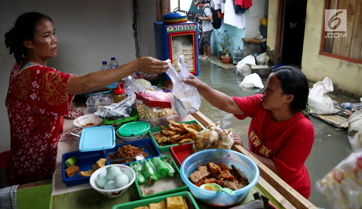 Aktivitas warga saat terjadi banjir rob yang menggenangi perkampungan/rumah mereka di Muara Angke, Jakarta, Kamis (4/1). Banjir rob ini terjadi lantaran pengaruh dari Super Moon, sehingga mengakibatkan debit air naik. (Liputan6.com/JohanTallo)
