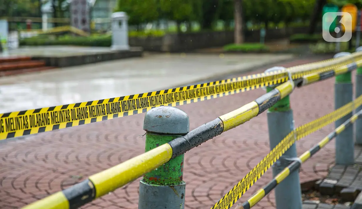 Garis dilarang melintas dipasang di sekitar Taman Menteng, Jakarta, Kamis (31/12/2020). Pemprov DKI Jakarta mulai hari ini menutup sementara seluruh taman dan hutan kota di Ibu Kota jelang Tahun Baru 2021 untuk mengantisipasi penyebaran virus Covi-19. (Liputan6.com/Faizal Fanani)