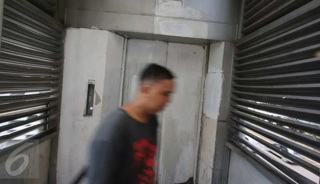 Warga melintas di depan lift khusus lansia dan ibu hamil yang rusak di JPO Sarinah, Jakarta, Kamis (2/3). Kurangnya perhatian pihak terkait menyebabkan lift tersebut menjadi terbengkalai serta tidak berguna. (Liputan6.com/Immanuel Antonius)