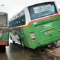 Bus Mayasari Bakti jurusan Pulo Gadung - UKI tersangkut pembatas Busway di jalan Perintis Kemerdekaan, Jaktim, Sabtu (23/1) akibat menghindari truk saat hujan deras. (Antara)