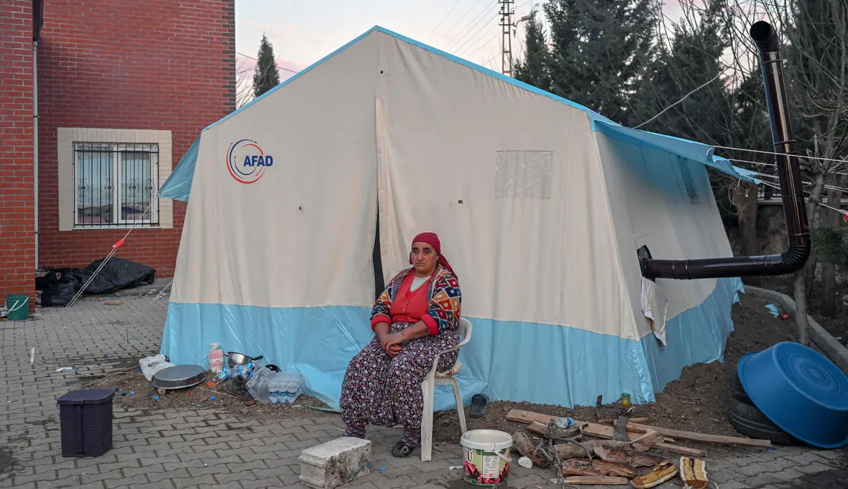 Seorang wanita duduk di depan tenda daruratnya di desa Yaylakonak distrik Adiyaman, Turki, Minggu (19/2/2023). 108 jiwa meninggal dan 170 rumah ambruk di Desa Yaylakonak distrik Adiyaman, Turki akibat gempa berkekuatan 7,8 magnitudo yang terjadi pada 6 Februari lalu. (BULENT KILIC/AFP)