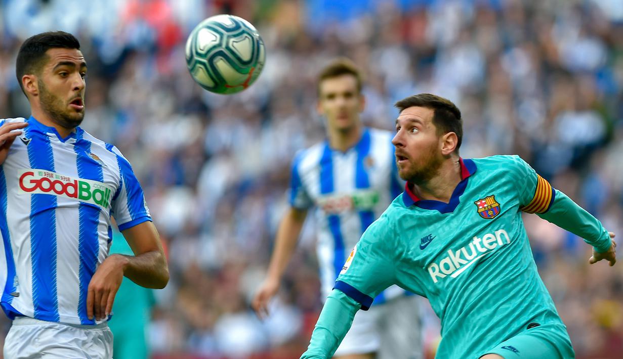 Striker Barcelona, Lionel Messi, berebut bola dengan gelandang Real Sociedad, Mikel Merino, pada laga La Liga di Stadion Anoeta, San Sebastian, Sabtu (14/12). Kedua klub bermain imbang 2-2. (AFP/Ander Gillenea)