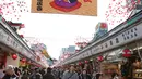 Pejalan kaki melintas di bawah dekorasi shio babi tanah yang mengarah ke kuil Buddha Asakusa Sensoji di Tokyo, Jepang, Kamis (27/12). Tahun 2019 dipercaya menjadi waktu yang tepat untuk menghasilkan uang dan berinvestasi. (AP Photo/Koji Sasahara)