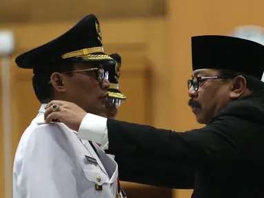 Gubernur Jawa Timur Soekarwo (kanan) melantik Bupati Tulungagung terpilih hasil Pilkada 2018, Syahri Mulyo di Jakarta, Selasa (25/9). Syahri saat ini sudah berstatus tahanan KPK. (Merdeka.com/Imam Buhori)