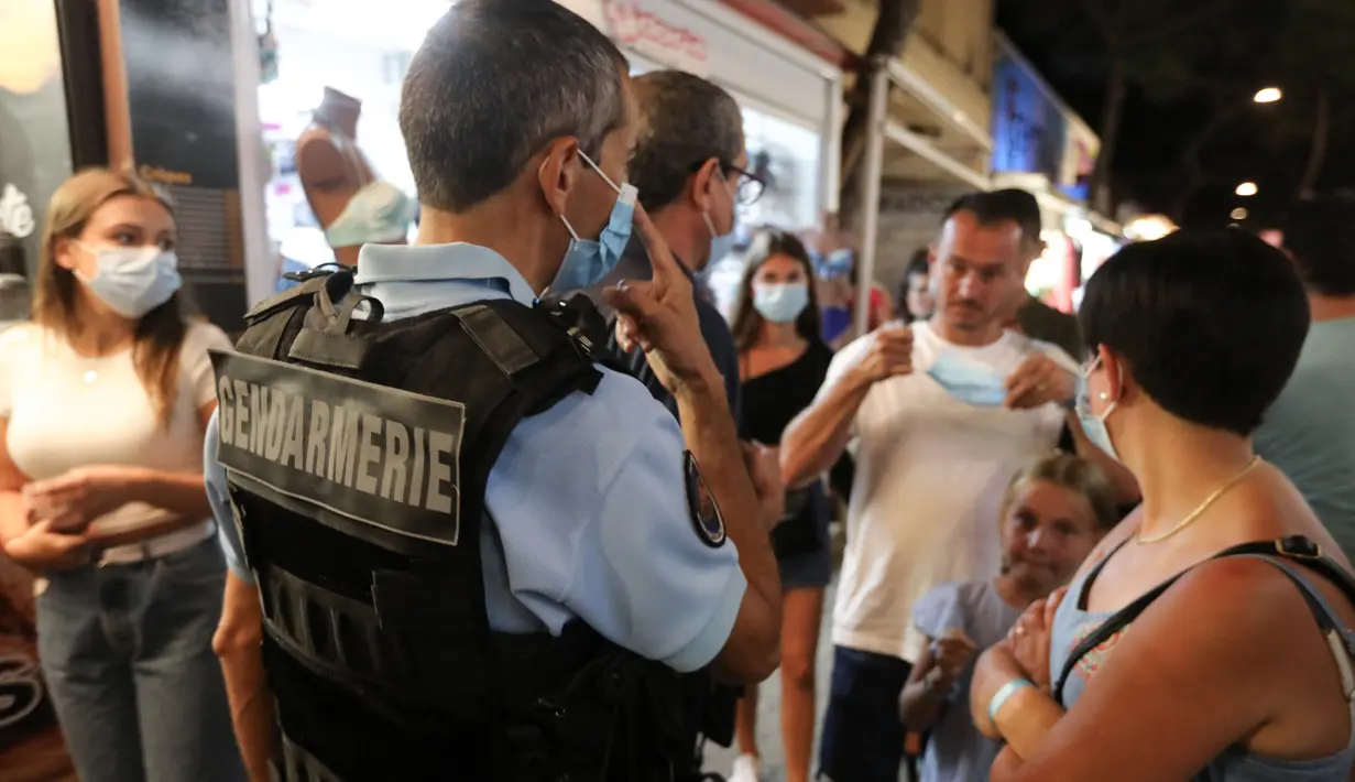 Polisi Prancis berpatroli untuk mengontrol kewajiban penggunaan masker di jalan-jalan Argeles-sur-Mer, Prancis selatan, Rabu (13/8/2020). Pemakaian masker di beberapa area ramai di sekitar Paris merupakan kewajiban sebagai upaya untuk membendung peningkatan tajam infeksi covid-19. (RAYMOND ROIG/AFP)