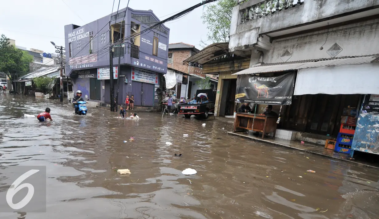 Warga kemang Utara menunggu genangan air surut, Jakarta, Rabu (20/7). Akibat intensitas hujan deras yang mengguyur Jakarta, sejumlah ruas jalan tergenang air. (Liputan6.com/Yoppy Renato)