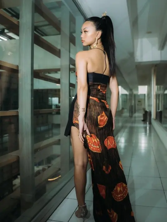 Saat merayakan bersama fansnya, Naura mengenakan gaun dengan train panjang serta belahan di bagian bawah yang memamerkan kakinya. Serta dipadukan heels warna silvernya.  Credit: (@naura.ayu)