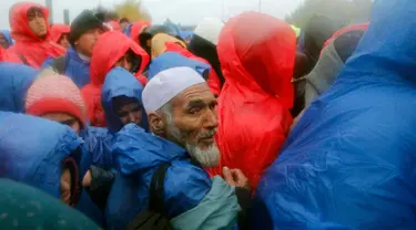 Para pengungsi saat menunggu menyeberang perbatasan dari Slovenia menuju Trnovec, Kroasia, Senin (19/10). Ribuan orang terjebak cuaca dingin di desa perbatasan Serbia Berkasovo setelah Kroasia membendung para pendatang. (REUTERS/Antonio Bronic)