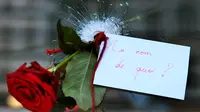 Bunga Mawar ditancapkan pada lubang jendela yang pecah akibat serangan penembakan yang terjadi di di Paris, Prancis, Sabtu (14/11/2015). Dikabarkan ratusan orang tewas dalam serangan ini. (REUTERS/Christian Hartman)