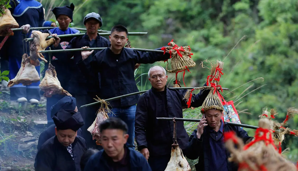 Orang-orang dari etnis minoritas Miao membawa persembahan ketika mereka menghadiri upacara pengorbanan untuk dewa gunung di Jianhe di provinsi Guizhou barat daya China (15/4). (AFP Photo/China Out)