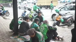 Aktivitas pengemudi ojek daring di depan Cibubur Junction, Jakarta, Selasa (24/3/2020). Merebaknya Covid-19 menyebabkan aktivitas di kawasan itu lesu yang juga berimbas pada turunnya pendapatan pengemudi ojek online hingga lima kali lipat dibanding hari biasanya. (Liputan6.com/Immanuel Antonius)