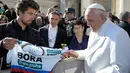 Juara sepeda Slovakia Peter Sagan menawarkan jersey yang dipakai saat menjadi juara dunia kepada Paus Fransiskus pada akhir audiensi mingguan di Vatikan (24/1). (AFP/HO/Osservatore Romano)