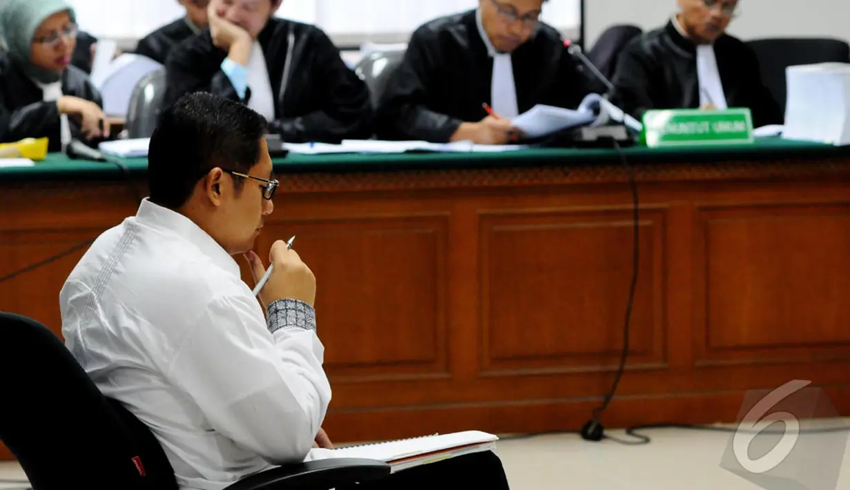 Anas Urbaningrum berhenti sejenak untuk menulis sambil mendengarkan tuntutan jaksa, Jakarta, Kamis (11/9/2014) (Liputan6.com/Andrian M Tunay)
