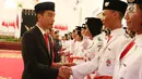Presiden Jokowi bersalaman dengan anggota Paskibraka Nasional 2017 saat pengukuhan di Istana Negara, Jakarta, Selasa (15/8). Paskibra ini nantinya akan mengibarkan bendera merah putih pada upacara peringatan HUT RI-ke 72. (Liputan6.com/Angga Yuniar)