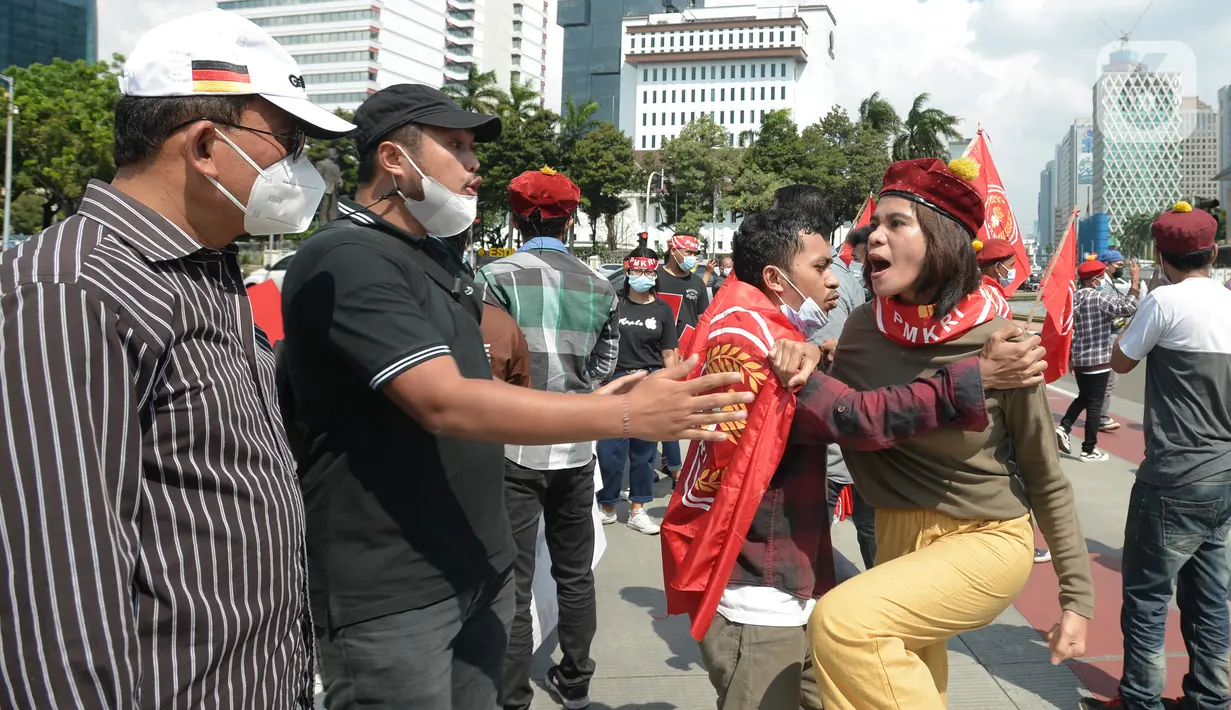Suasana saat massa gabungan dari berbagai elemen buruh dan organisasi mahasiswa berunjuk rasa memperingati Hari Buruh atau May Day di area Patung Kuda, Jakarta, Sabtu (1/5/2021). Polisi mengamankan sejumlah massa yang diduga mahasiswa dalam aksi unjuk rasa tersebut. (merdeka.com/Imam Buhori)