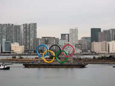 Kapal tongkang membawa Cincin Olimpiade di Distrik Odaiba, Tokyo, Jepang, Jumat (17/1/2020). Cincin Olimpiade dengan tinggi 15,3 meter dan panjang 32,6 meter tersebut akan berada di sana hingga Olimpiade 2020 berakhir. (AP Photo/Jae C. Hong)