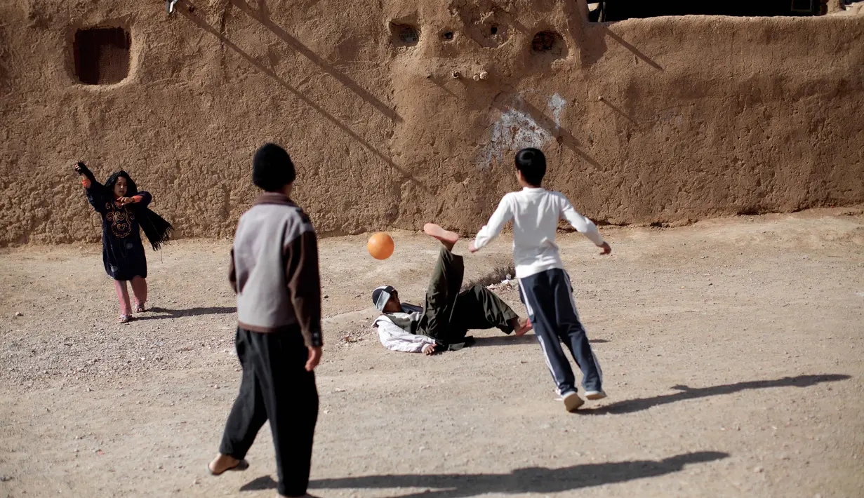 Anak-anak Afganistan bermain bola di tempat pengungsian Shahid Nasseri, Desa Taraz Nahid, 130 km dari Teheran,Minggu (8/02/2015). (AFP Photo/Behrouz Mehri)