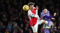 Pemain Arsenal, Martin Odegaard (kiri) berebut bola dengan pemain Liverpool, Andrew Robertson pada laga lanjutan Liga Inggris 2023/2024 di Emirates Stadium, London, Inggris, Minggu (05/02/2024) WIB. (AFP/Ian Kington)