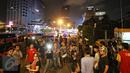 Warga tampak berkerumun di sekitar Gedung Jaya, Jalan MH Thamrin, Jakarta, setelah sebuah ledakan kembali terdengar, Kamis (14/1). Ledakan sempat membuat Jalan MH Thamrin kembali ditutup pada malam hari. (Liputan6.com/Immanuel Antonius)