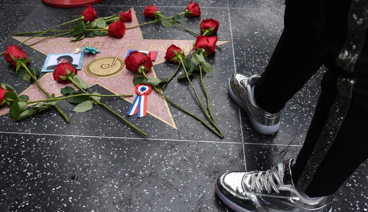 Bunga dari penggemar diletakan di Hollywood Walk of Fame Michael Jackson memperingati sepuluh tahun kematian superstar itu di Los Angeles, Selasa (25/6/2019). Tepat pada hari ini sepuluh tahun yang lalu berita kematian King of Pop Michael Jackson mengguncang dunia. (Chris Pizzello/Invision/AP)