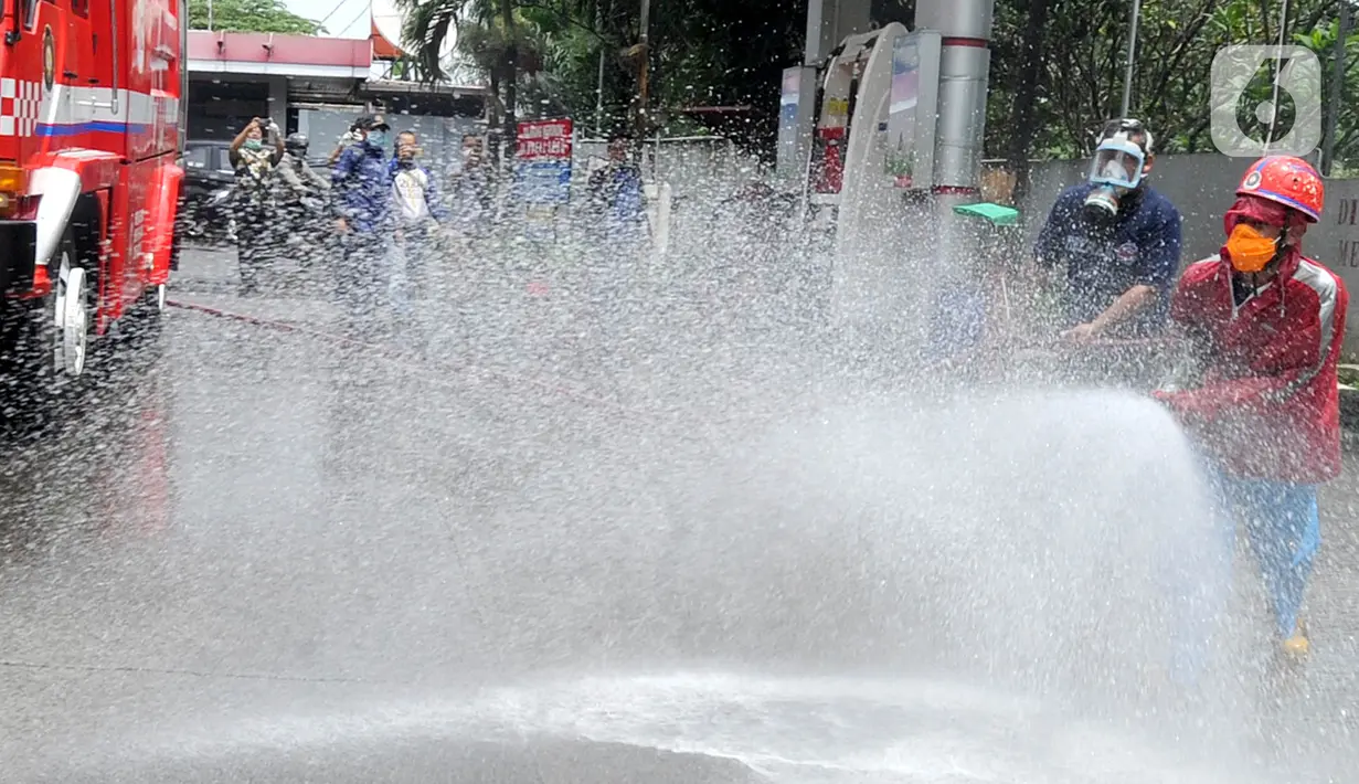 Petugas Pertamina dan Damkar melakukan penyemprotan disinfetaktan di SPBU depan RS Azra, Bogor, Jawa Barat, Jumat (27/03/2020). Penyemprotan disinfetaktan kerjasama PT Pertamina (Perseo) dan Dinas Pemadam Kebakaran Kota Bogor. (merdeka.com/Arie Basuki)