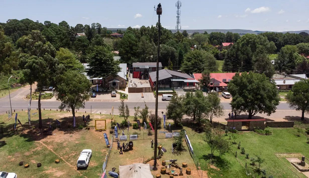 Pandangan aerial memperlihatkan Vernon Kruger, 52, berdiri dalam tong di atas tiang dengan ketinggian 25 meter di Dullstroom, Afrika Selatan, 16 Januari 2020. Kruger telah tinggal di atas tong selama dua bulan demi memecahkan rekor dunia untuk orang terlama yang hidup di tong. (ANTOINE DEMAISON/AFP)