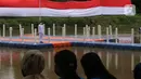 Warga saat menyaksikan pengibaran bendera merah putih di Sungai Cisadane, Kota Tangerang, Banten, Kamis (28/10/2021). Pengibaran bendera merah putih yang di ikuti puluhan pemuda tersebut di lakukan untuk memperingati hari sumpah pemuda. (Liputan6.com/Angga Yuniar)