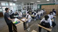 Siswa senior menghadiri kelas di Gimhae High School di Gimhae, Korea Selatan, Rabu, (20/5/2020). Siswa Korea Selatan mulai kembali ke sekolah pada hari Rabu ketika negara mereka bersiap untuk normal baru di tengah pandemi coronavirus. (Kim Dong-min / Yonhap via AP)