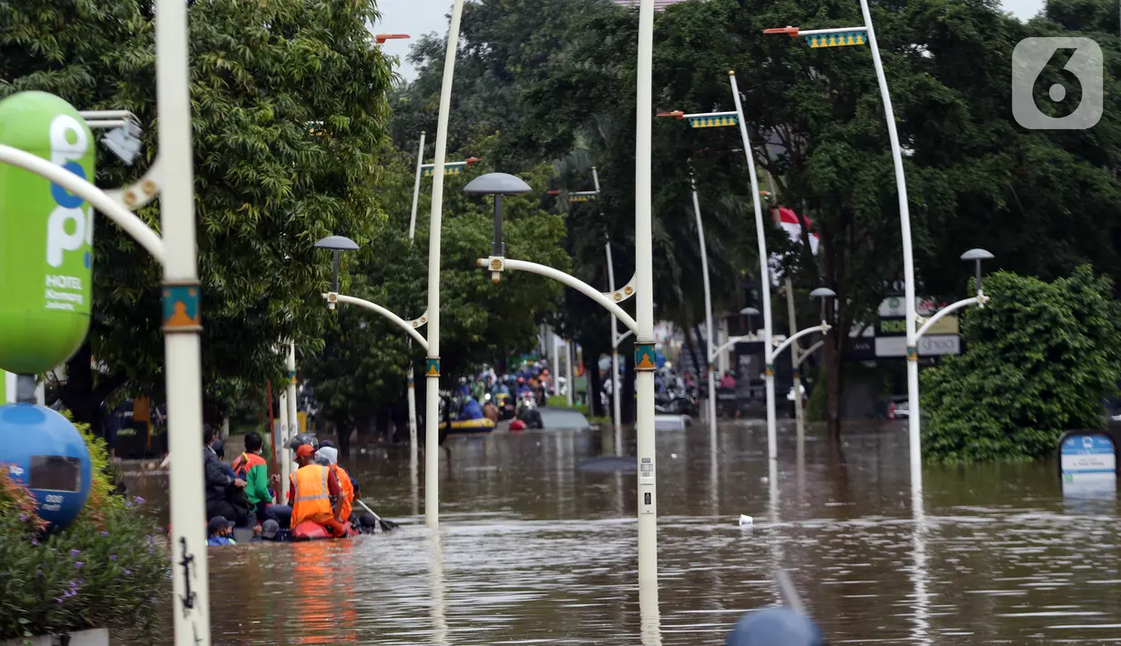 Petugas menggunakan perahu karet mengevakuasi beberapa warga yang terjebak banjir di kawasan Jalan Kemang Raya, Jakarta, Sabtu (20/2/2021). Hujan yang mengguyur Jakarta sejak Jumat (19/2) membuat sejumlah titik di Jakarta terendam banjir. (Liputan6.com/Helmi Fithriansyah)
