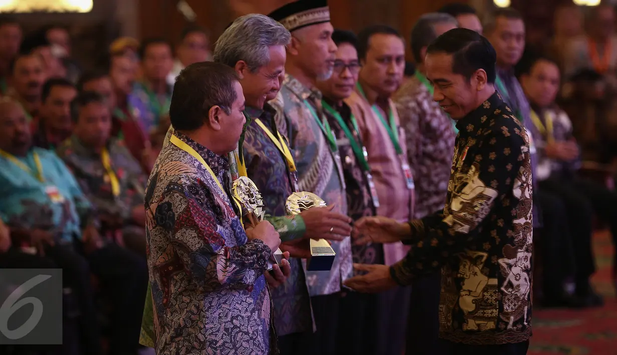 Presiden Jokowi (kanan) ketika memberikan piala anugerah Tim Pengendalian Inflasi Daerah (TPID) pada daerah yang terpilih dalam acara pembukaan Rakornas ke-7 TPID Tahun 2016 di Jakarta, Kamis (4/8). (Liputan6.com/Faizal Fanani)
